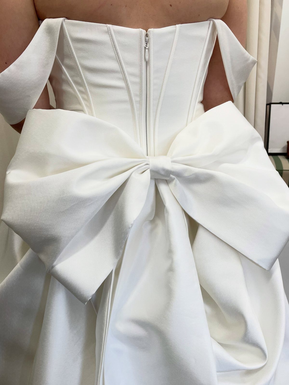 2026 Wedding Dresses: 12 Bridal Styles to Know Right Now 6 Back view of a white wedding dress with a corset bodice and a large oversized bow.