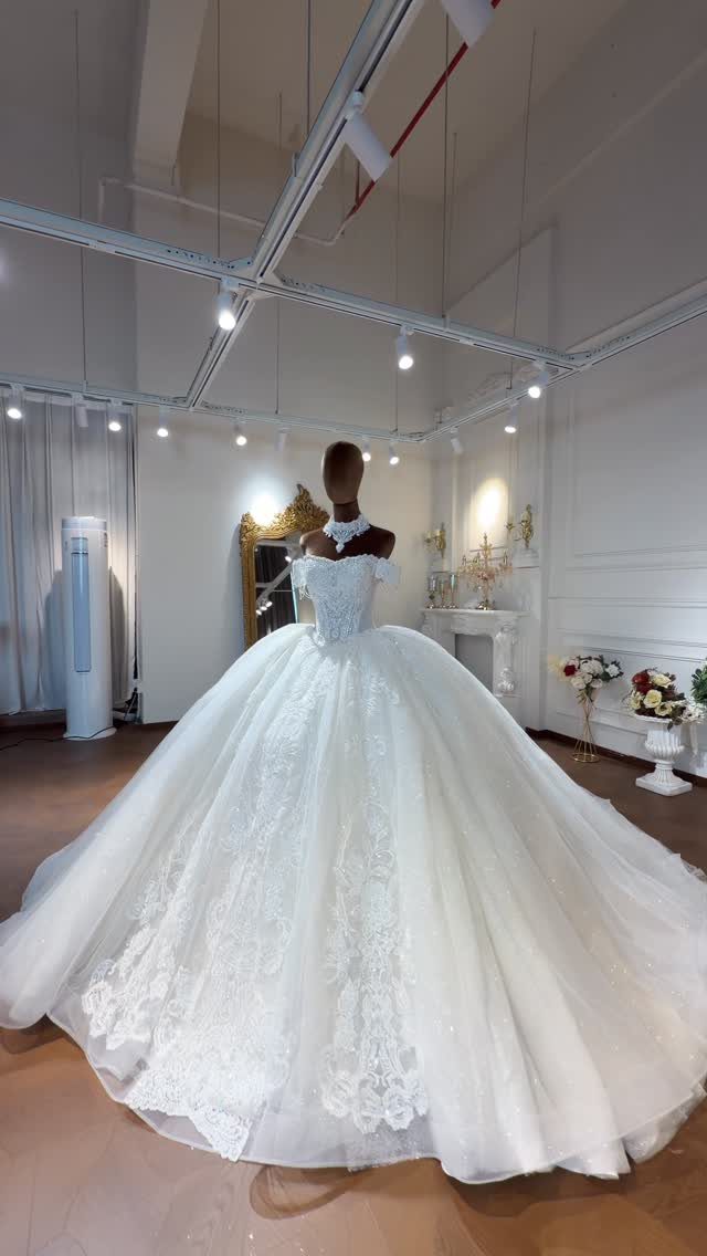 2026 Wedding Dresses: 12 Bridal Styles to Know Right Now 11 A voluminous white lace wedding gown displayed on a mannequin in a bright studio.