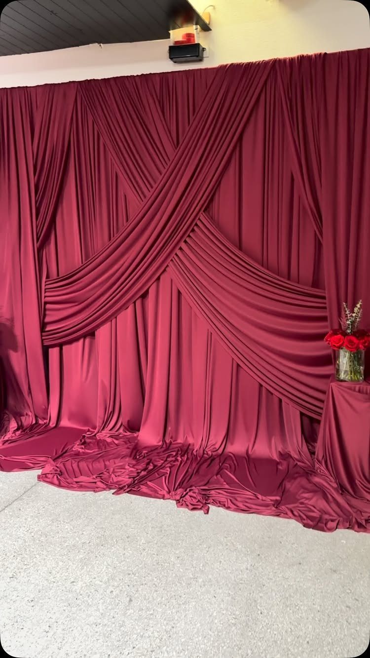 Dark Red Wedding Colors: 20 Ideas for Mood and Palette 6 Deep red draped fabric backdrop with elegant crisscross swags and heavy folds.