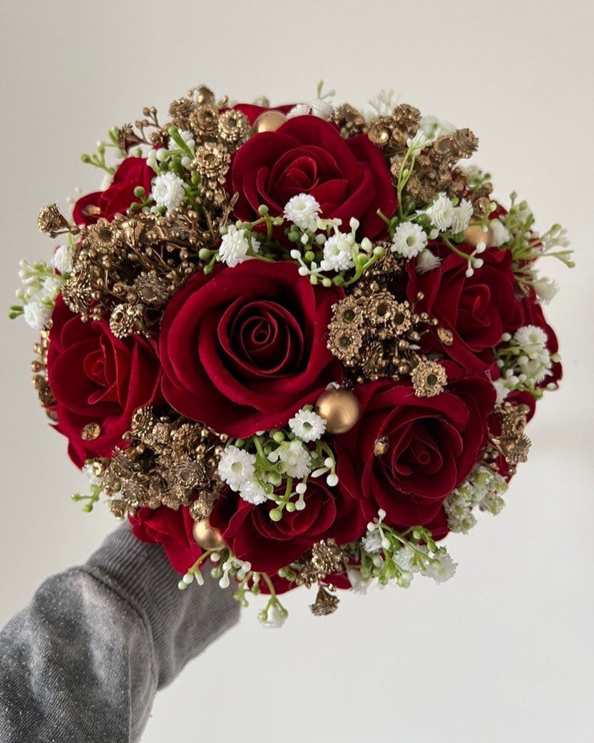Dark Red Wedding Colors: 20 Ideas for Mood and Palette 20 A handheld bouquet of deep red roses, white baby's breath, and gold-painted floral accents.