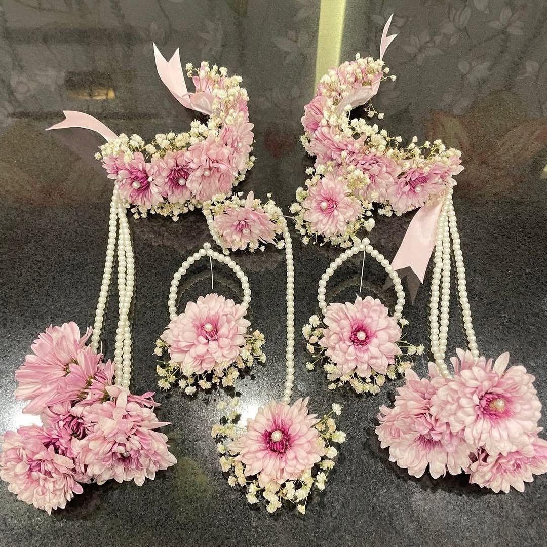 Pink and white floral jewelry set with pearl strands laid on a dark surface.