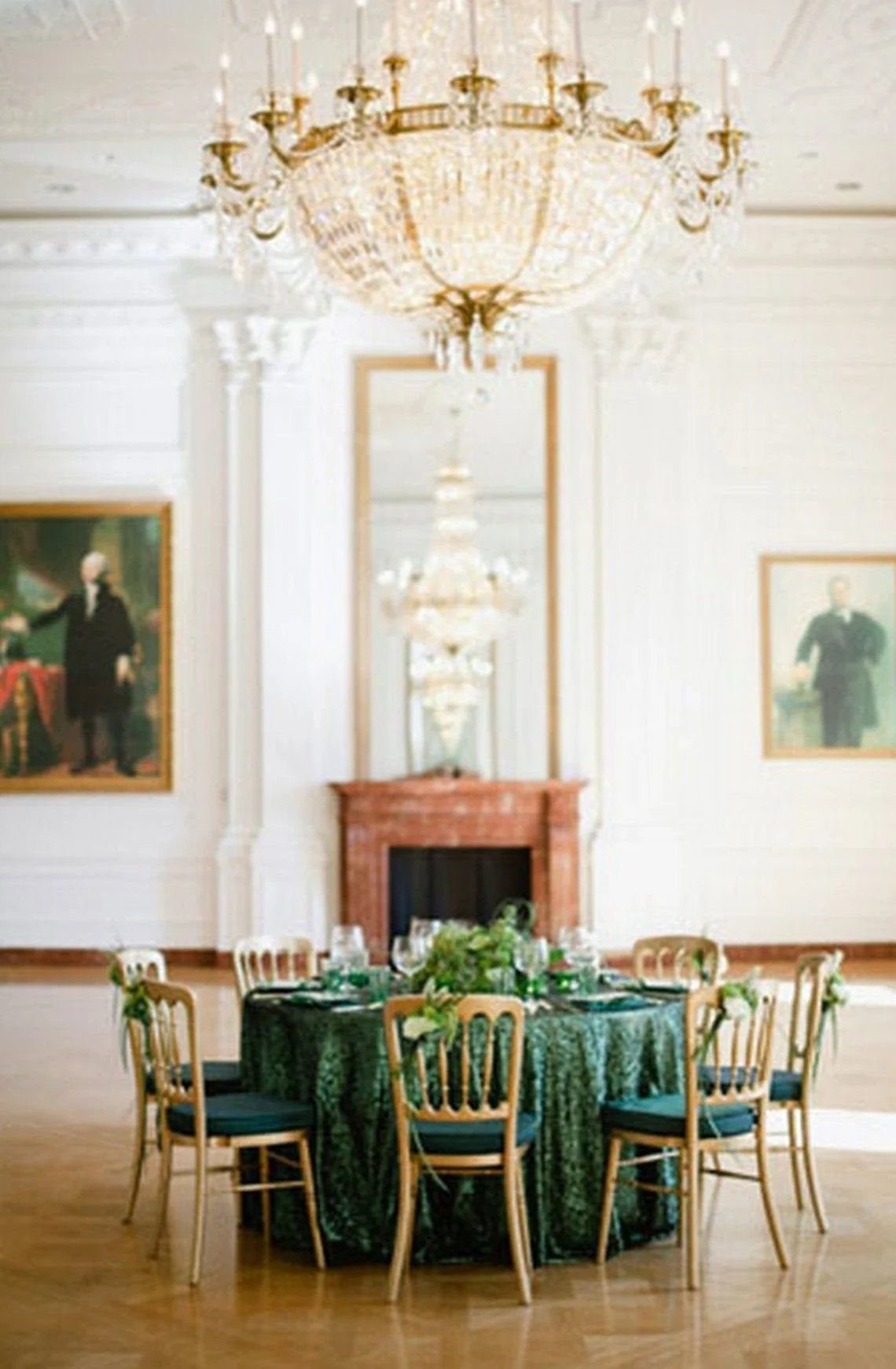 Green Gold White Wedding: 8 Ideas for Decor and Details 5 A round wedding table featuring a sparkling emerald green sequin tablecloth and gold chairs in a ballroom.