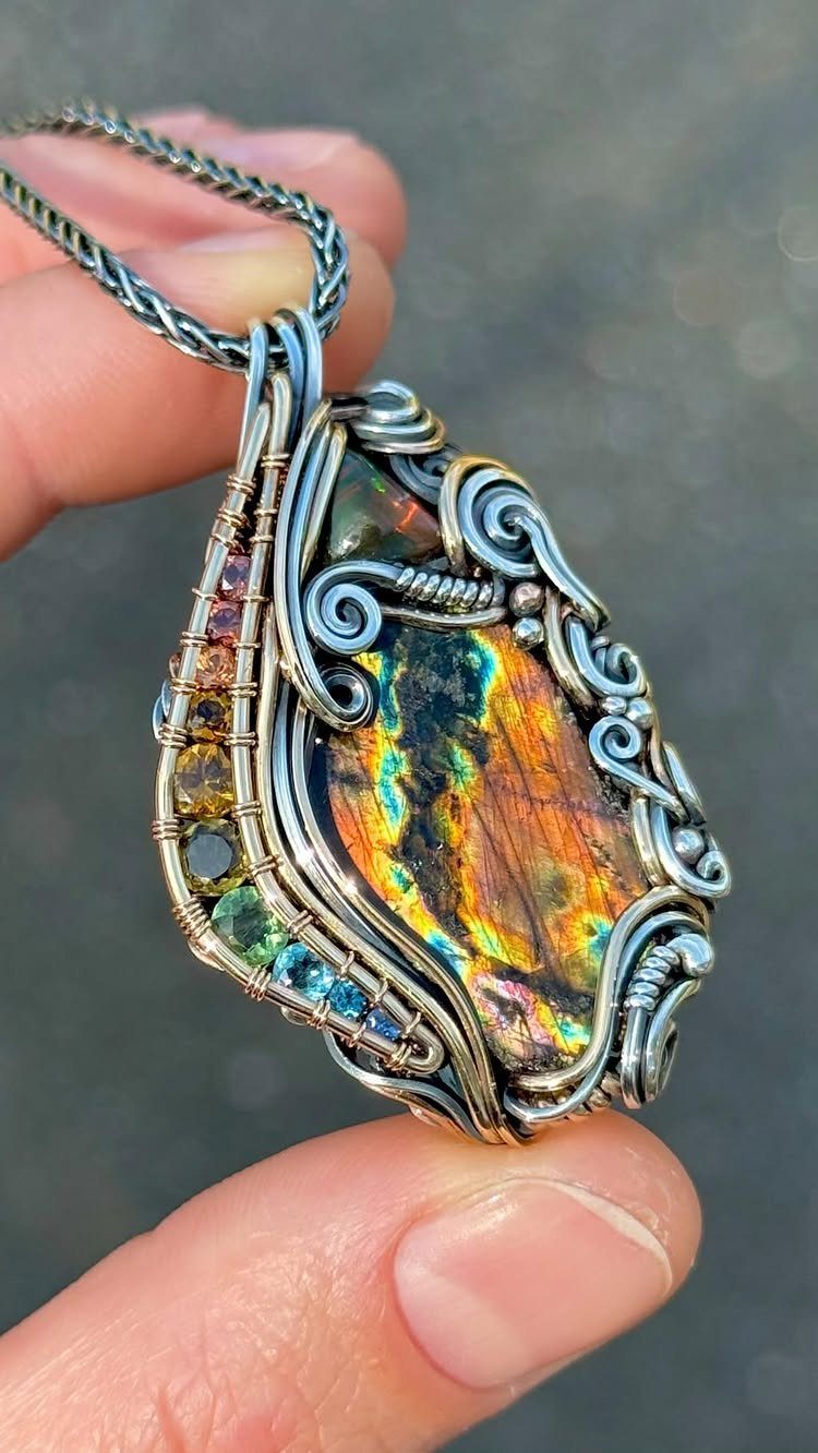 Precious Stones Jewelry: 11 Ideas From Emerald to Gold Bangles 10 A hand holding a large, wire-wrapped labradorite pendant with colorful iridescent flashes.