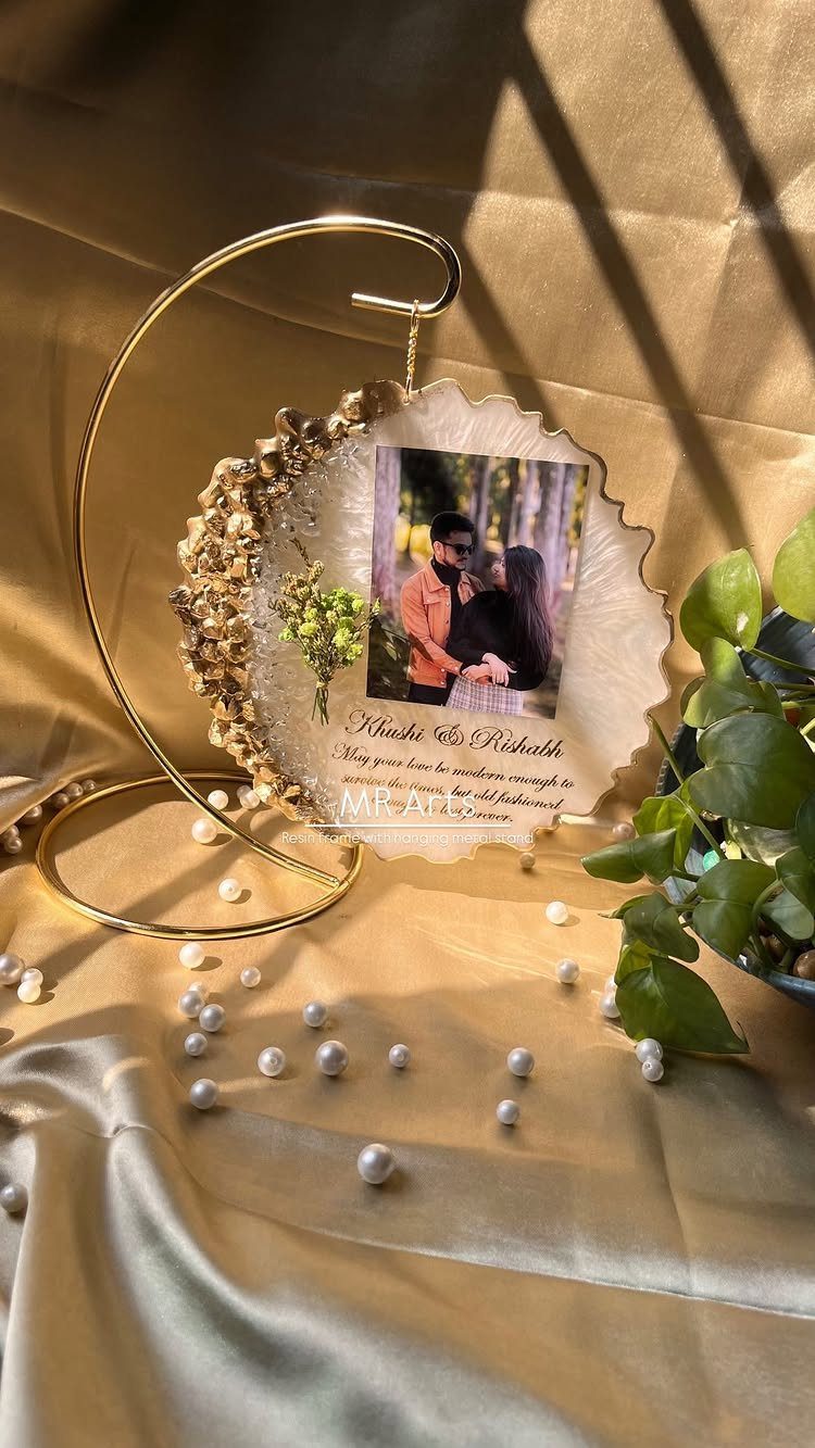 Rehearsal Dinner Gift Ideas: 9 Ways to Thank Your People 3 A decorative gold circular frame holding a scalloped photo of a couple on gold fabric.