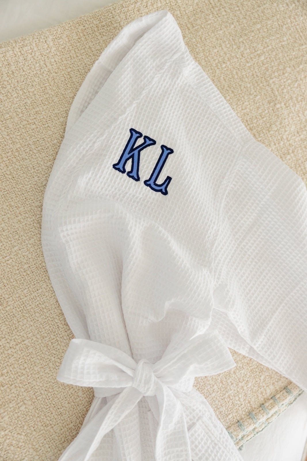 Rehearsal Dinner Gift Ideas: 9 Ways to Thank Your People 6 White waffle-weave bathrobe with blue embroidered initials KL on the chest.