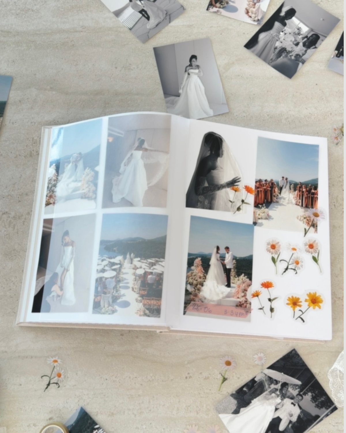 Rehearsal Dinner Gift Ideas: 9 Ways to Thank Your People 5 An open wedding photo album surrounded by loose black and white wedding photographs and small flowers.