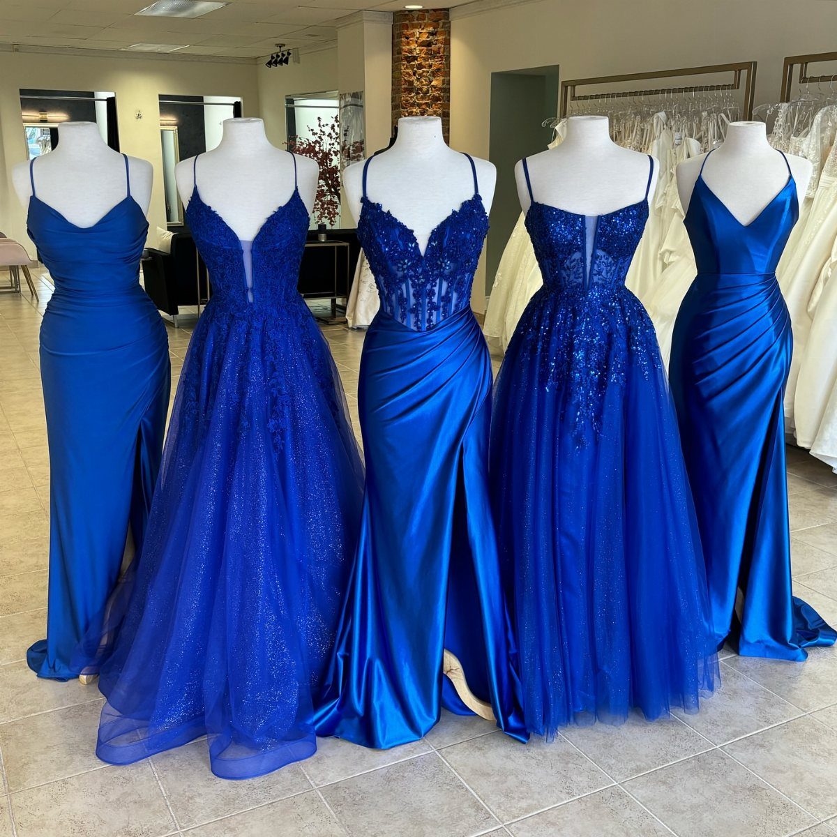 Wedding Colors Royal Blue: 9 Ideas for Your Reception 1 Five different styles of royal blue bridesmaid dresses displayed on white mannequins.