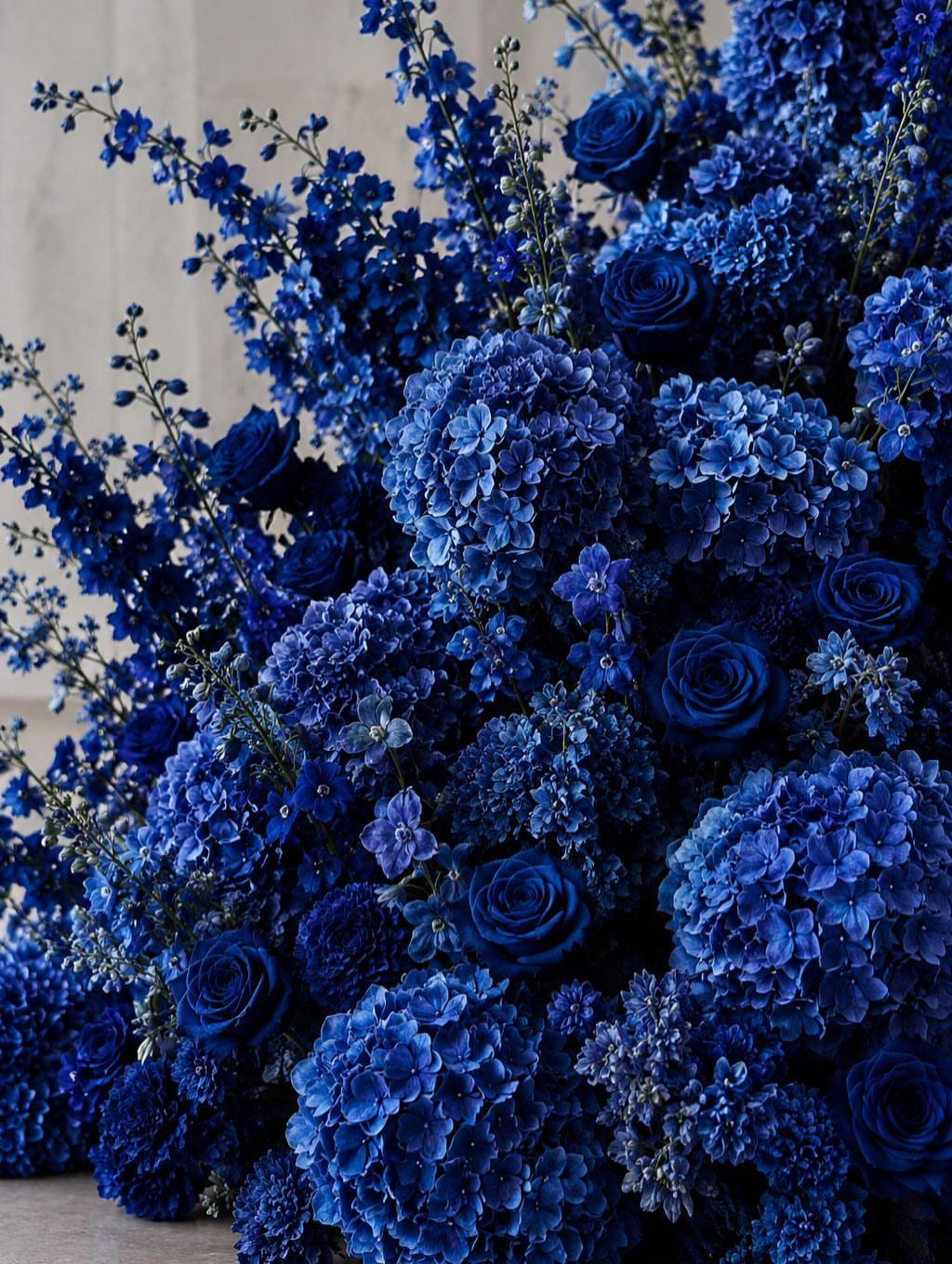 Wedding Colors Royal Blue: 9 Ideas for Your Reception 4 A large, dense arrangement of various blue flowers including roses and hydrangeas.