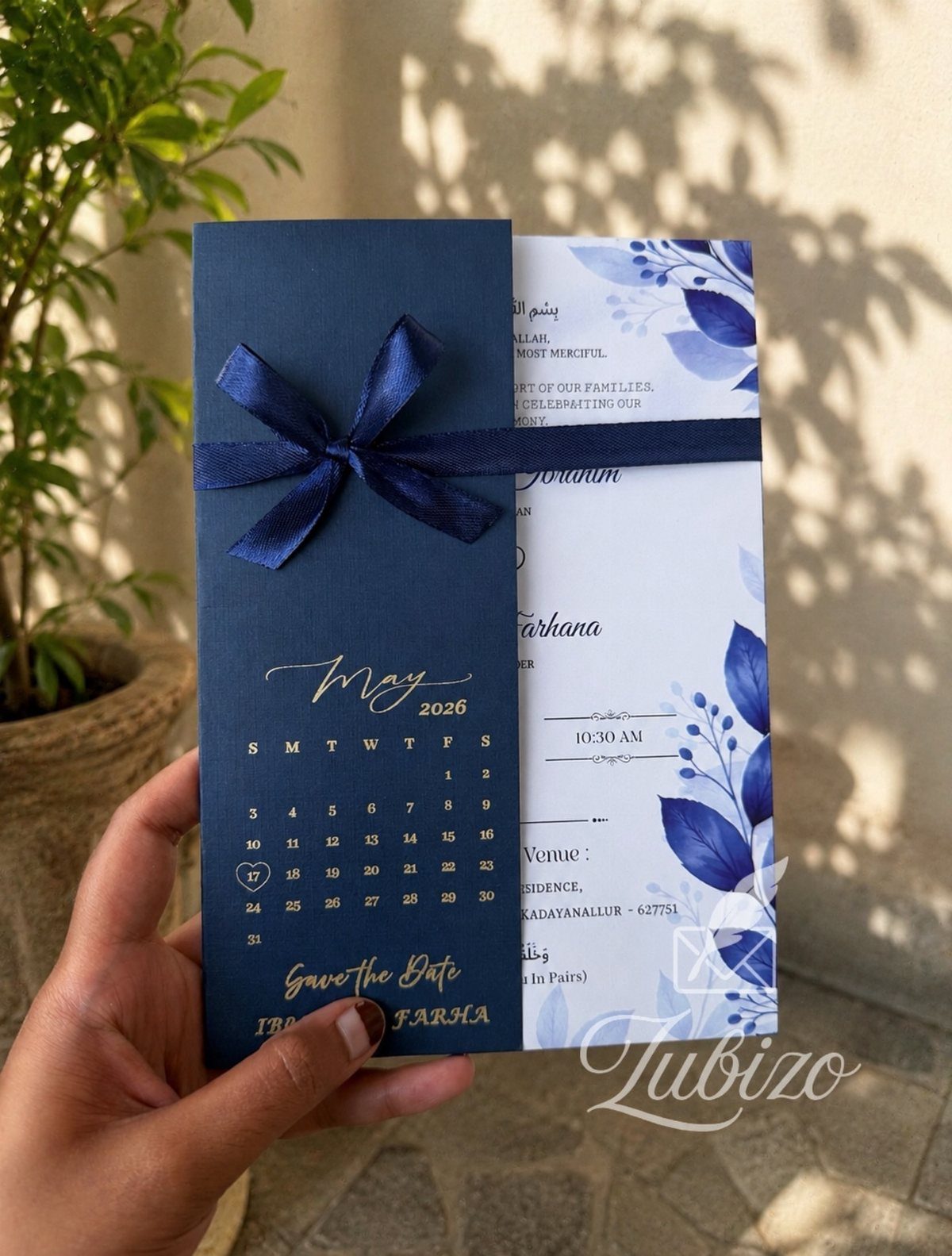 Wedding Colors Royal Blue: 9 Ideas for Your Reception 9 A hand holding a royal blue wedding invitation with gold lettering and blue floral patterns.