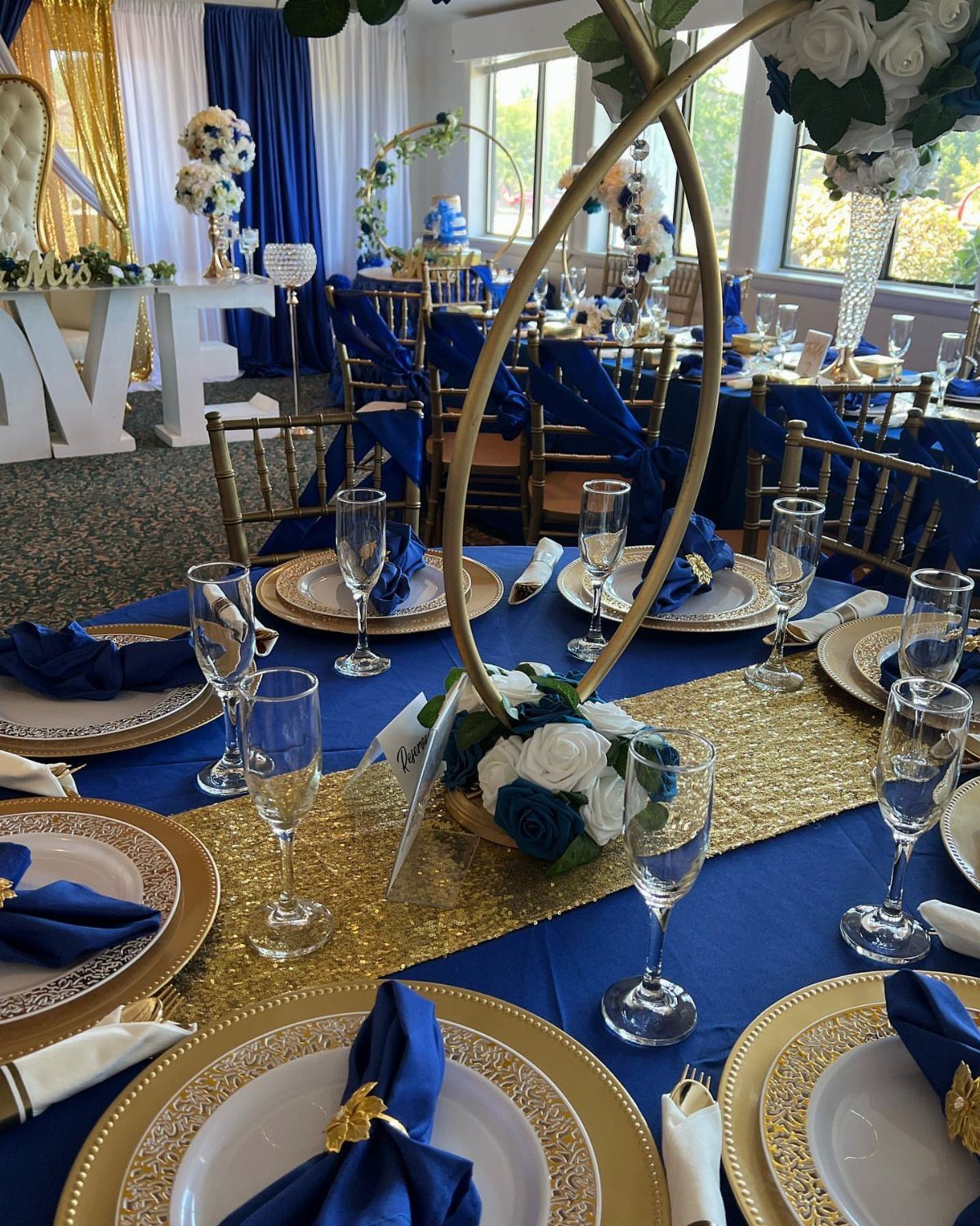 Wedding Colors Royal Blue: 9 Ideas for Your Reception 2 Wedding table setting featuring royal blue linens, gold sequin runners, and gold chargers with floral centerpieces.