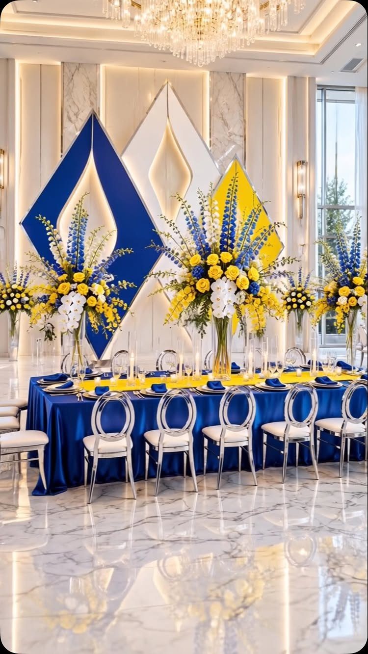 Wedding Colors Royal Blue: 9 Ideas for Your Reception 5 A long banquet table set with royal blue linens, yellow napkins, and large blue and yellow floral arrangements.