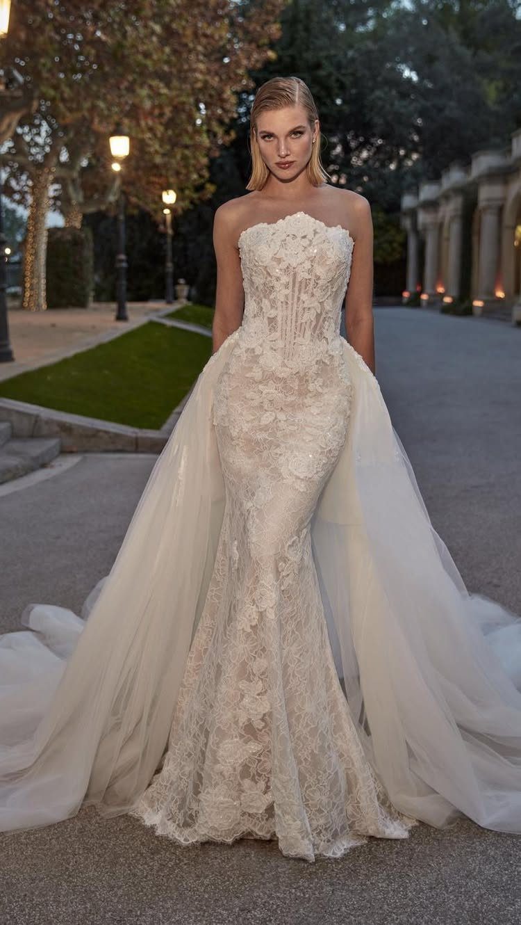 Wedding Dress with Overskirt: 5 Styles to Consider 1 A woman in a lace mermaid wedding dress with a large tulle overskirt standing outdoors.