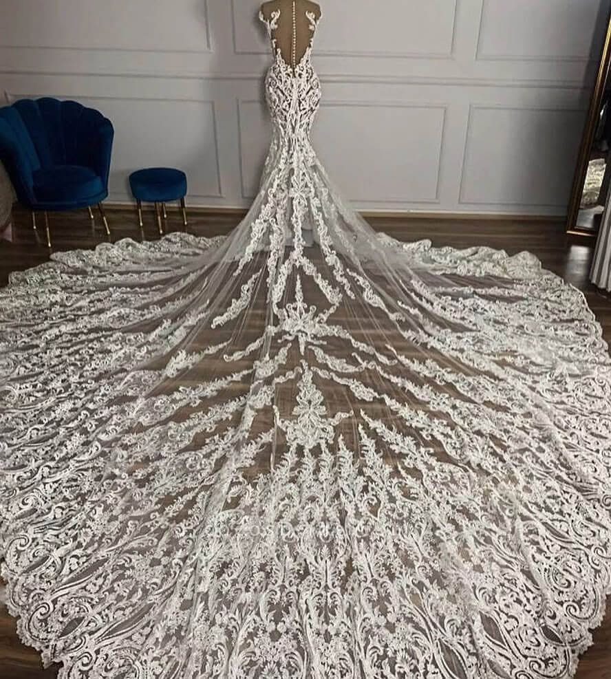 Wedding Dress with Overskirt: 5 Styles to Consider 2 Lace mermaid wedding dress with an expansive, intricately embroidered lace train spread across a floor.
