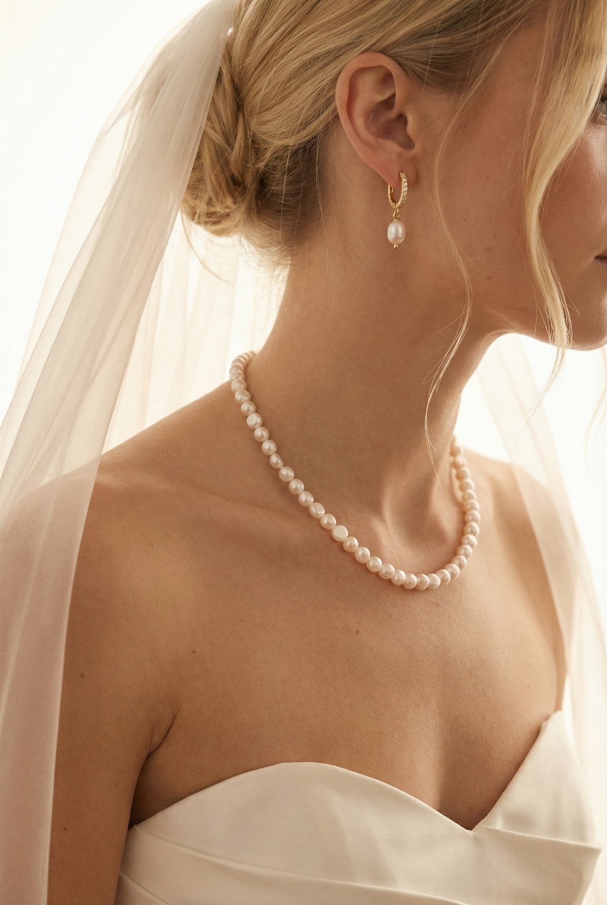 Wedding Dress with Pearl Necklace: 5 Styling Ideas That Work 1 A blonde bride wearing a white wedding dress and a single strand pearl necklace.