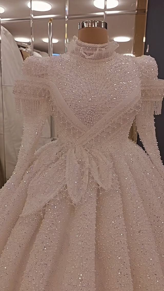 Wedding Dress with Pearl Necklace: 5 Styling Ideas That Work 5 A white wedding dress heavily embellished with sequins and pearls on a mannequin.