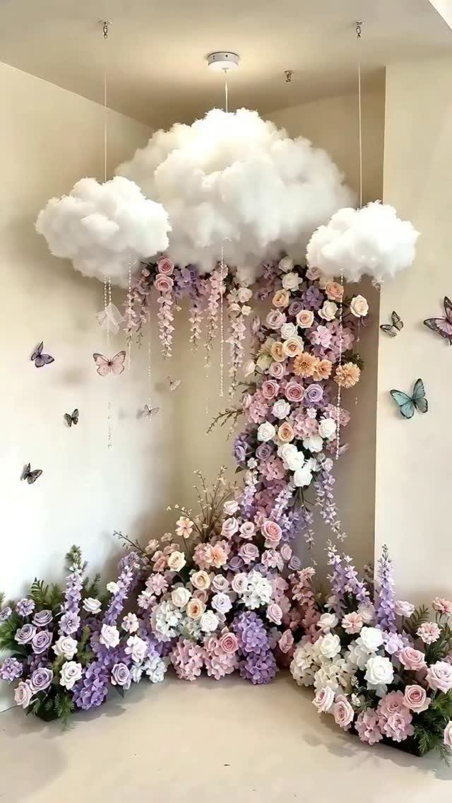 White fluffy clouds hanging above cascading pink and purple flowers with butterflies on the wall.